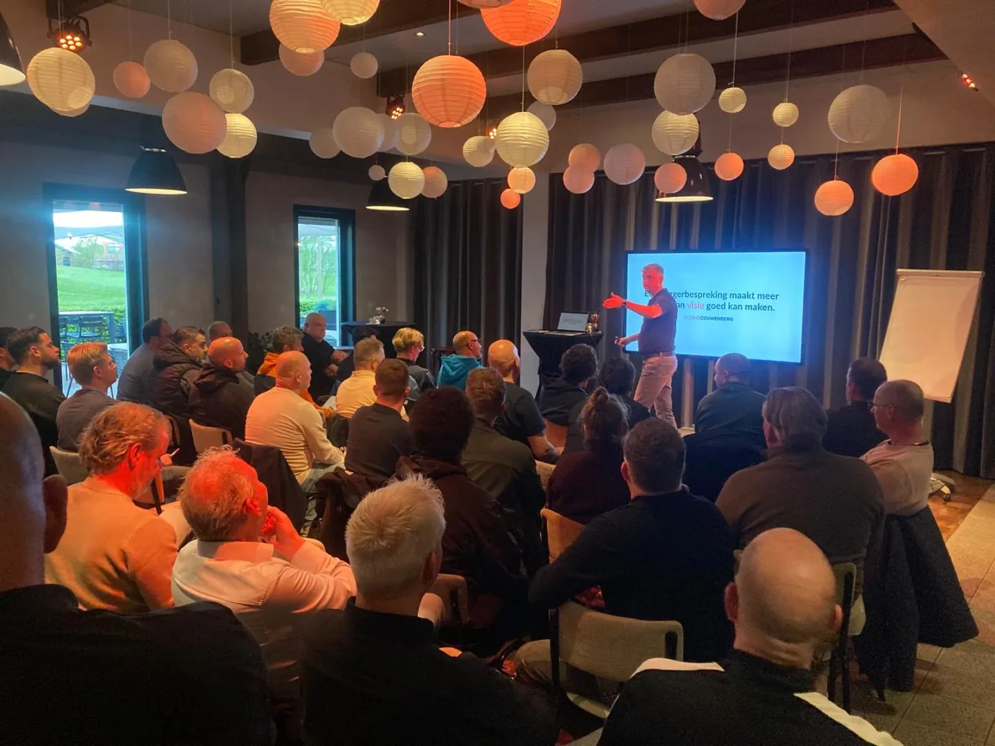 Ronnie Couwenberg tijdens de KNVB-workshop Stel je wedstrijdbespreking scherp en presenteer om te Winnen voor een volle zaal voetbalcoaches in KOMAEN in Oirschot, met op het scherm zijn stelling: een baggerbespreking maakt meer kapot dan visie goed kan maken.