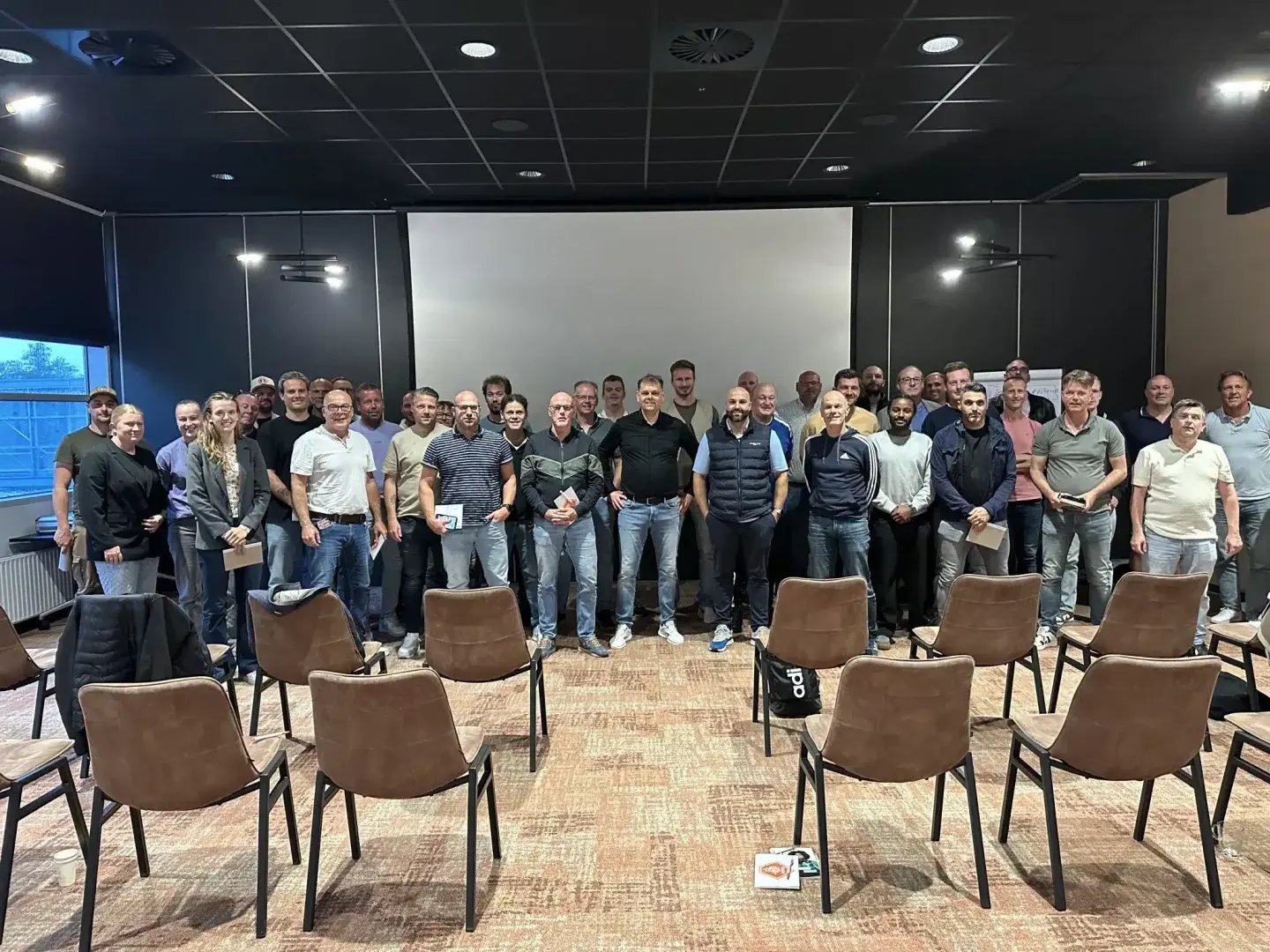 Ronnie Couwenberg met 40 voetbalcoaches na zijn KNVB-bijscholing over effectieve wedstrijdbesprekingen in Groningen.